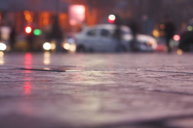 Akşam yağmuru, akşam vakti şehrin sokaklarında yansımalar yaratır..