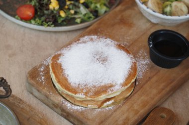 Pudra şekerle kaplanmış, şurupla servis edilen yumuşak bir krep..