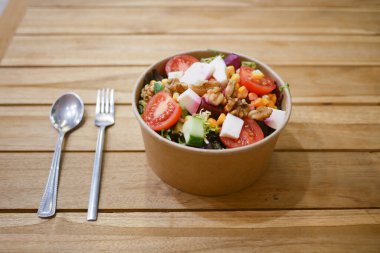 Taze sebze ve malzemelerle dolu canlı bir salata kasesi..