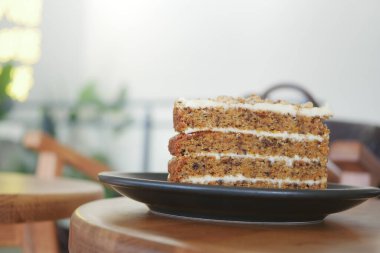 Bir dilim ıslak havuçlu kek siyah bir tabakta sunulur..