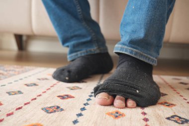 Kanepede otururken kirli çoraplı erkekler .