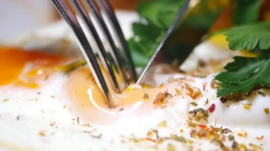 Mükemmel pişmiş bir yumurtayı otlarla kesmenin tadını çıkar..