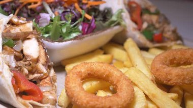 Kızarmış patates ve taze salatayla lezzetli tavuk dürümleri..