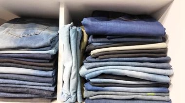 Mağazalardaki raflarda çeşitli kot pantolonlar ve günlük gömlekler düzenlendi..