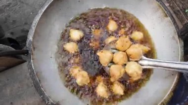 Kalabalık bir mutfakta leziz atıştırmalıkları kızartma sürecinin tadını çıkar..