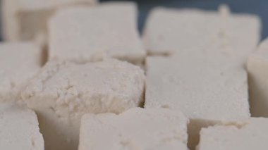 Bir dilim soya peynirinin yavaşça masaya düşmesi. .