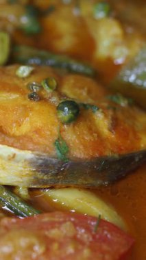 Canlı sebzeler ve baharatlarla dolu zengin bir sosta kaynatılmış taze balık..