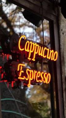 Parlak neon levhada kafenin dışında kapuçino ve espresso ikram ediliyor.