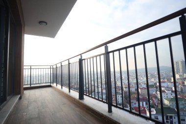 Geniş bir balkon aşağıdaki şehri büyüleyici bir şekilde görüyor..