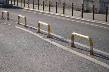 Sarı ve beyaz trafik engelleri bir şehir yolunun kenarında..