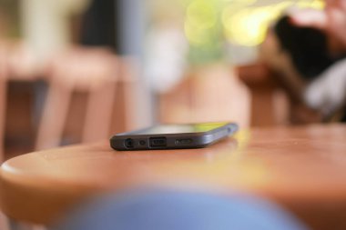 Seyyar cihaz, rahat bir kafedeki ahşap bir masada dinleniyor..