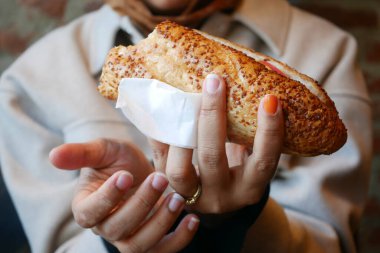 Bir insan sıcak bir kafede taze bir sandviçin tadını çıkarır..