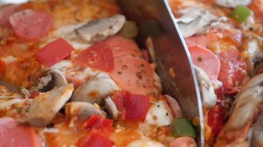 Arkadaşlar taze malzemelerle süslenmiş lezzetli bir pizzanın etrafında toplanır..