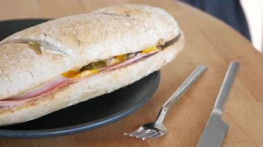 İnsan et ve sebzelerle dolu taze bir sandviçten zevk alır..