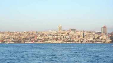 Canlı şehir silueti, akşam ışığında suyun üzerinde parlıyor..
