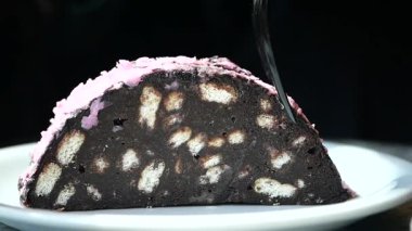 Pembe şekerli bir dilim çikolatalı tatlı servis edilir..