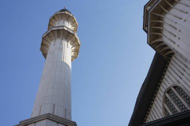 Göz kamaştırıcı bir minare, açık mavi gökyüzüne doğru yükseliyor..