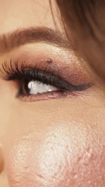 Göz makyajının detaylı görüntüsü kirpikleri ve ışıltılı efektleri vurguluyor.