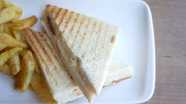 Lezzetli bir sandviç tabakta kızarmış patatesle eşleştirilir..