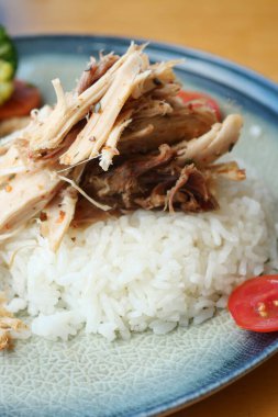 Dilimlenmiş tavuk, sebzeli yumuşak beyaz pirinç yatağında dinleniyor..