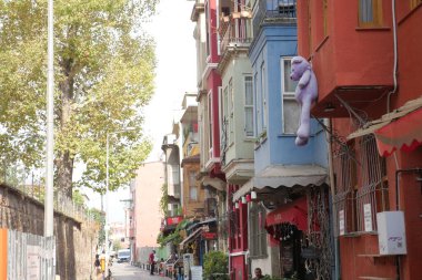 Canlı bir sokak gündüz renkli binalar ve kaprisli dekorlar sergiliyor.