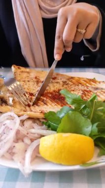 Lokantalar taze sebze ve limonla servis edilen ızgara balığın tadını çıkarırlar..