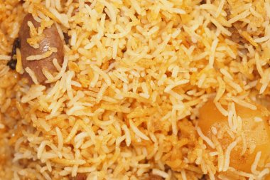 Lezzetli pirinç tabağı baharatlı et ısırıklarıyla eşleştirilmiş kabarık taneler sergiliyor..