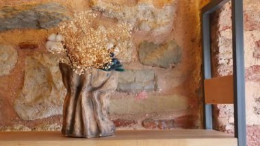 Tahta bir rafta kendine özgü bir vazoda güzel bir çiçek aranjmanı..