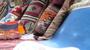 Ziyaretçiler Fas pazarındaki canlı el yapımı yastıklara hayranlar.