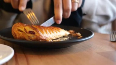 Kahvaltıda çatal ve bıçakla lezzetli bir hamur işinin tadını çıkarıyorum..