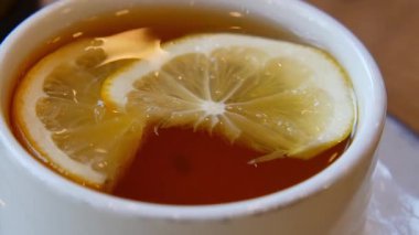 Limon dilimleriyle süslenmiş sıcak bir içecek hoş bir karşılama alanında içilir..