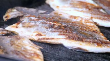 Taze tutulan balıklar kumsalın açık alevlerinde kızartılıyor..