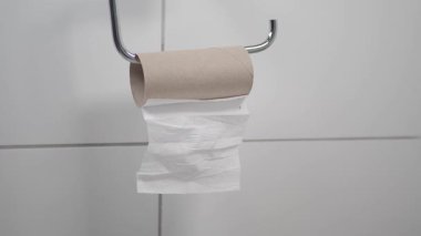 Neredeyse boş bir tuvalet kağıdı banyodaki bir tutacağa asılı..