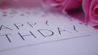 Güzel bir doğum günü kartı zarif pembe güllerle çevrilidir..