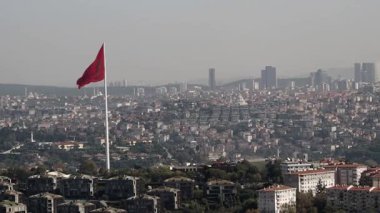 Şehrin üzerinde büyük bir bayrak dikiliyor, aşağıdaki şehir ortamını gözler önüne seriyor..