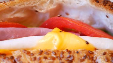 Sebze ve peynir katmanlarıyla dolu taze bir sandviçin yakın çekimi..