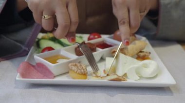 Kahvaltı için çeşitli peynirler, sebzeler ve etler tatmak..