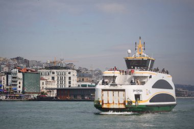 Bir feribot dalgalı bir sahile doğru yol alıyor..