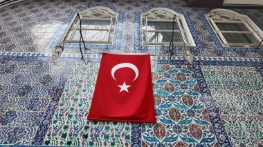 Çarpıcı bir Türk bayrağı parlak bir kiremit duvarda asılı.