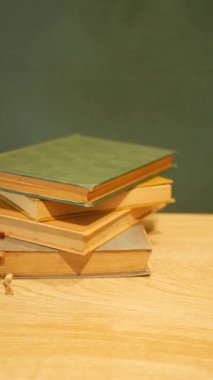 Ahşap bir yüzeye istiflenmiş ciltli kitap koleksiyonu..