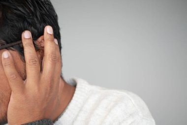 Kapalı alandaki ezici gürültüye tepki veren bir insan el ele tutuşur..