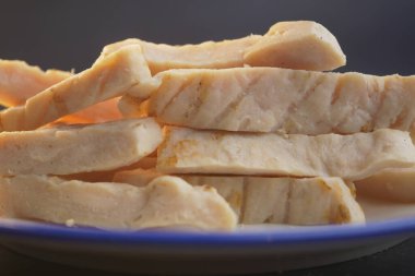Yumuşak, hafif bir arka planda narin tavuk göğsü dilimleri güzel bir şekilde gösterilir.