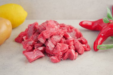 Çiğ et parçaları taze sebzelerle birlikte tezgahın üzerinde düzenlenir..