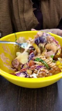 Bir yemek sırasında makarna ve sebzelerle canlı bir salata karışımı servis ediliyor..