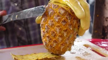 Yetenekli bir satıcı hevesli müşteriler için olgun bir ananas hazırlar..