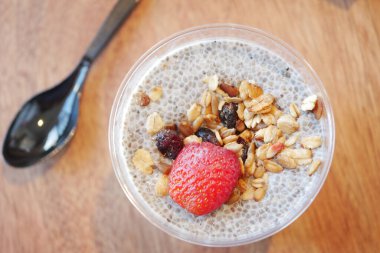 Yulaf ve böğürtlenli Chia pudingi ahşap bir masada oturur..