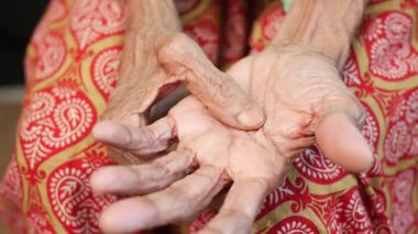 Yaşlanmış ellerin yavaşça dinlenmesi, deneyimi ve tarihi sembolize eder..