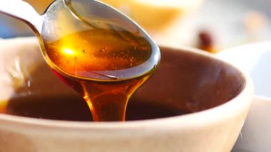 Kaşıktan kaseye dökülen bal. 