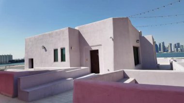 Parlak renkli binalar, güneşli bir kasabada yol boyunca uzanır..