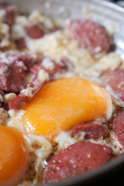 İki yumurta fırında sosis parçalarının yanında kızarıyor..